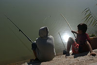 Мальчишки рыбачащие на озере